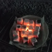 R Red cube charcoal briquettes burning evenly during a heat quality test.